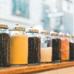 Photo of jars with dry goods lined up along a window sil